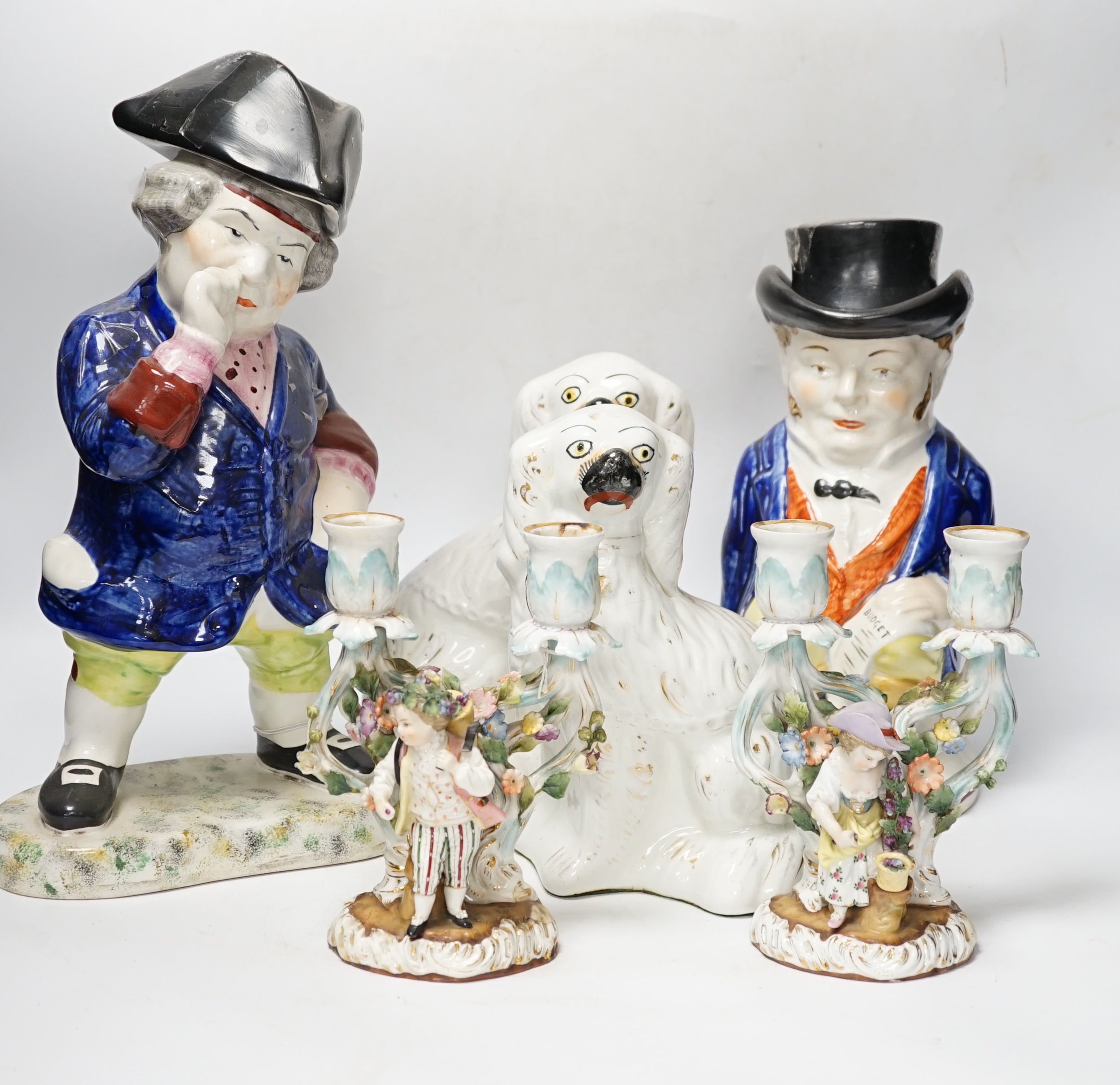 A pair of 19th century French figural two branch candelabra, 17cm high, together with two Staffordshire character jugs and a pair of Kings Charles Spaniel figures